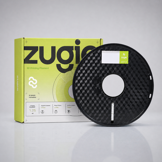 A spool of ZUGIO 3D printing filament in black, shown next to its lime green and white retail packaging box on a reflective white surface.